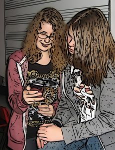 Two girls look at something together on a mobile phone