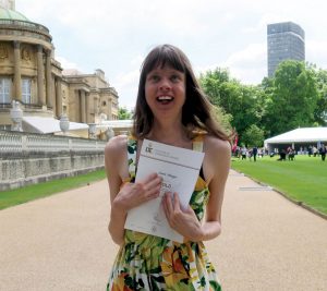 cover of Inclusion Now 48: a young disabled woman clutches her Duke of Edinburgh award certificate outside Buckingham Palace and smiles towards the sky