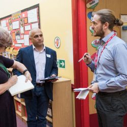 Headteacher Karl Hemmings talking in a corridor to Belinda and Navin