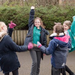 Four girls, disabled and non-disabled, playing in playground