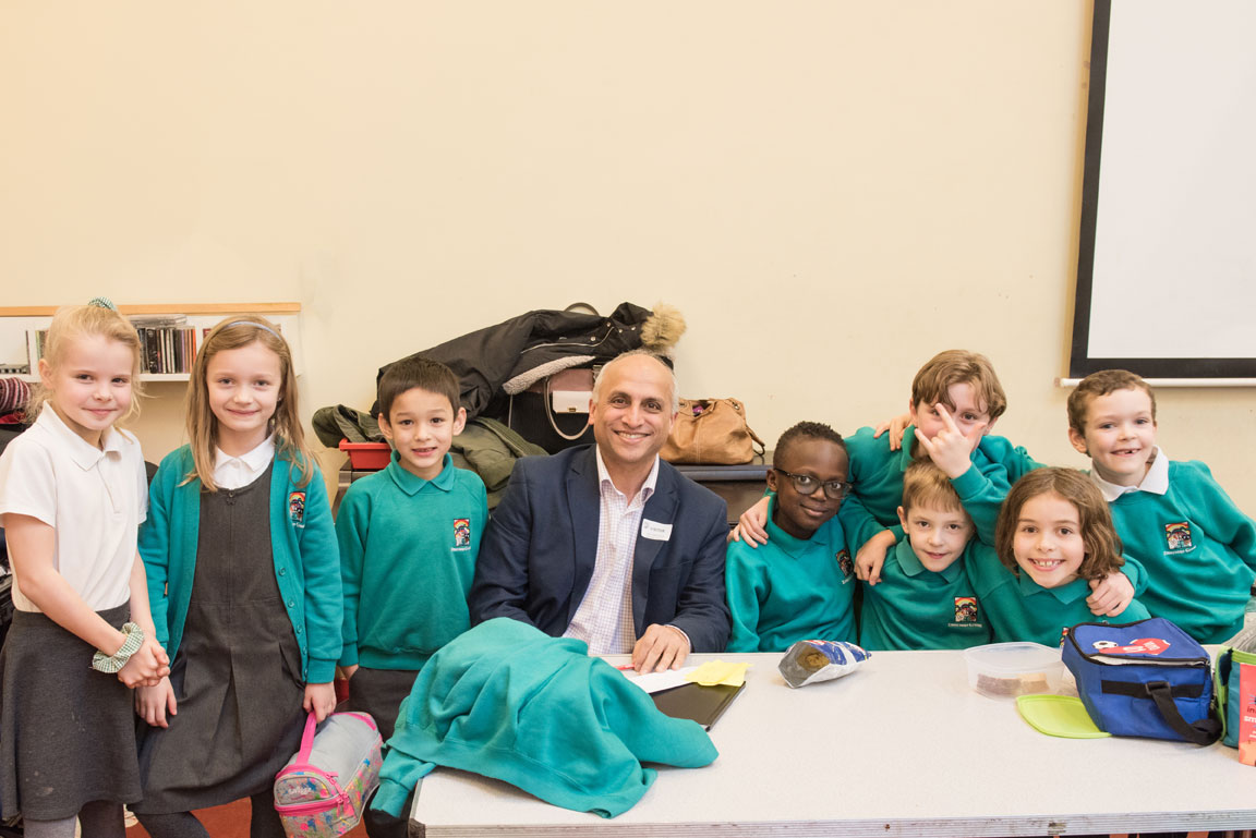 Navin, seated, surrounded by 8 children