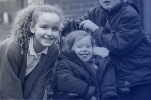 Two girls smiling, one with Down's Syndrome