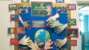 A classroom display with paper hands, paper globe and the words "share our similarities, celebrate our differences"