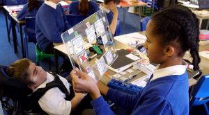 Jonathan Bryan and his class-mate pictured during a school lesson, using a spelling board to communicate.